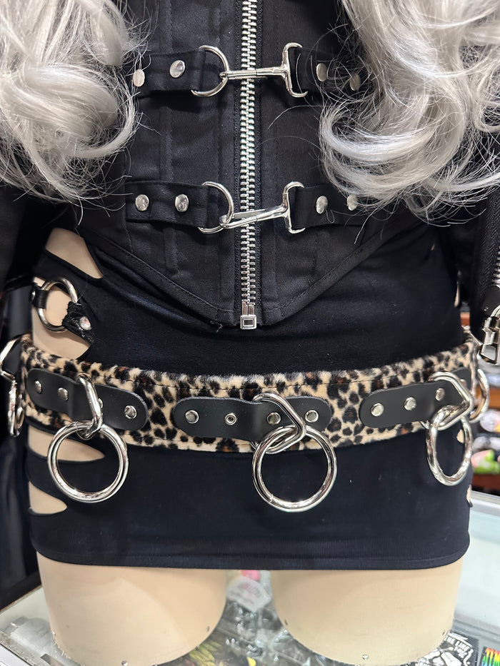 Mannequin wearing a black outfit with leopard print belt and silver rings.