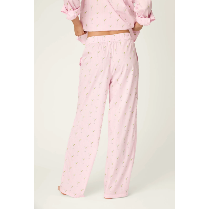 A person wearing light pink pajama pants with a small repeating leaf print and a matching pink top, shown from the back against a plain light background.