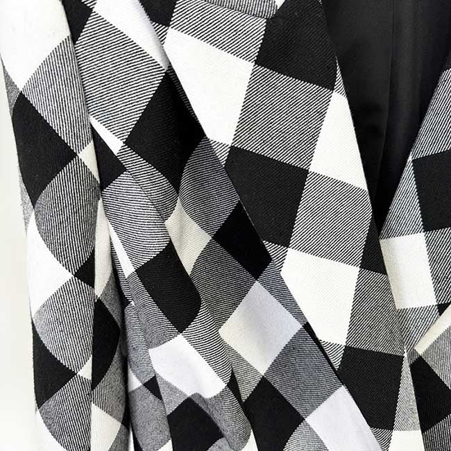 Close-up of women's black checked blazer coat showcasing bold check pattern and stylish design
