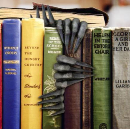 Black devil's claw hands bookmark inside of book