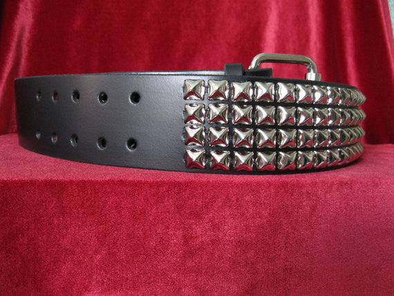 wide width black leather belt with four rows of silver pyramid studs. shows silver adjustable buckle
