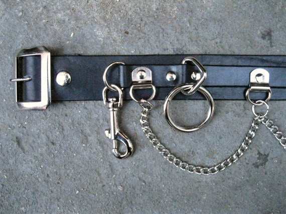 mannequin displaying black leather belt with five silver hanging bondage o rings and silver hanging chain