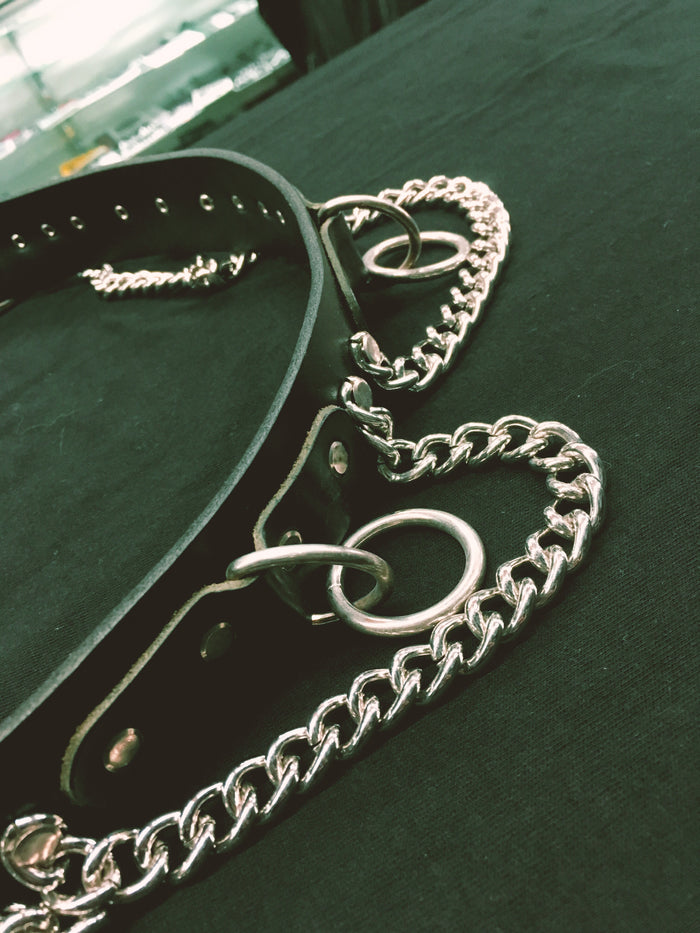 black bondage belt with silver hanging o rings and silver hanging chain