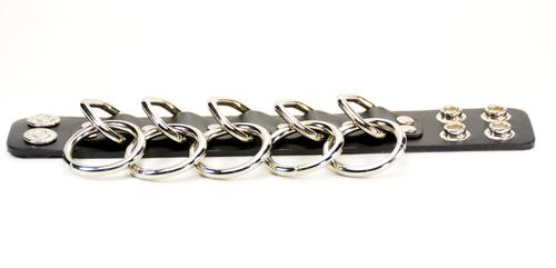 black leather bracelet with five silver d rings with five hanging silver o rings attached. shows snap closure