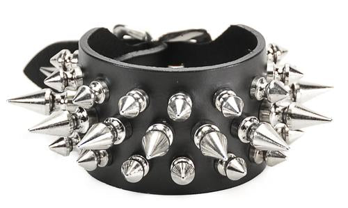 Black leather bracelet with three rows of silver spikes. Top and bottom row consist of 1/2" silver spikes. Center row consists of 1" silver spikes.
