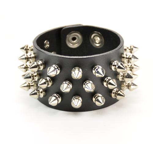 black leather bracelet with three rows of multiple silver spikes. shows snap closure