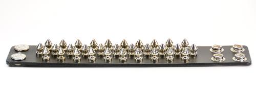 black leather bracelet with three rows of multiple silver spikes. shows snap closure
