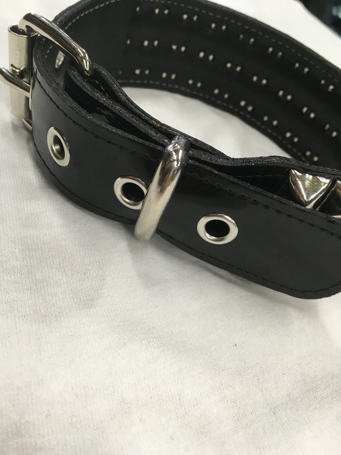 black leather collar with three rows of multiple silver pyramid studs. show adjustable buckle closure