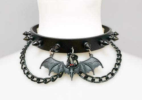 Black leather collar with 1/2" black spikes, black hanging chain, and black bat with red eyes hanging from the front center.