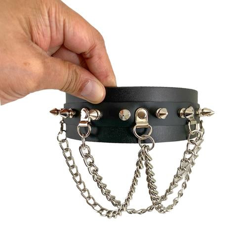 Black leather collar with silver spikes and small silver D rings with attached silver hanging looped chains.