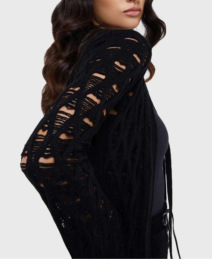 Model wearing a black floor length cardigan on a white background