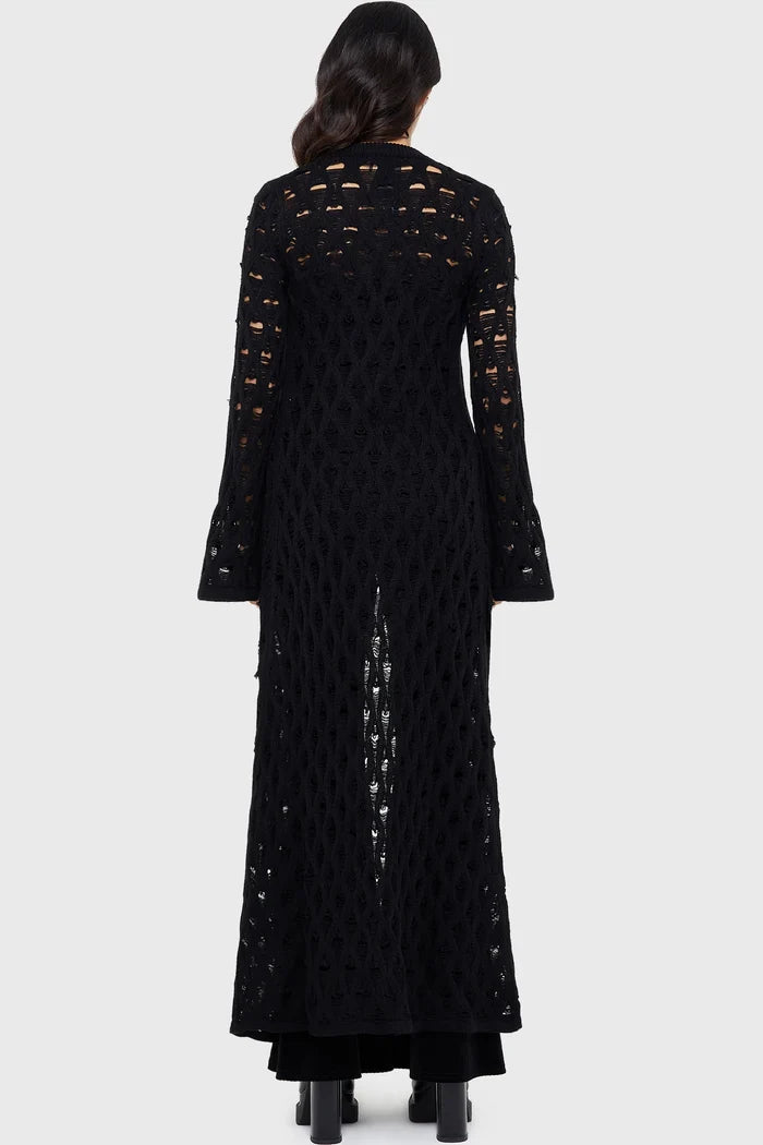 Model wearing a black floor length cardigan on a white background