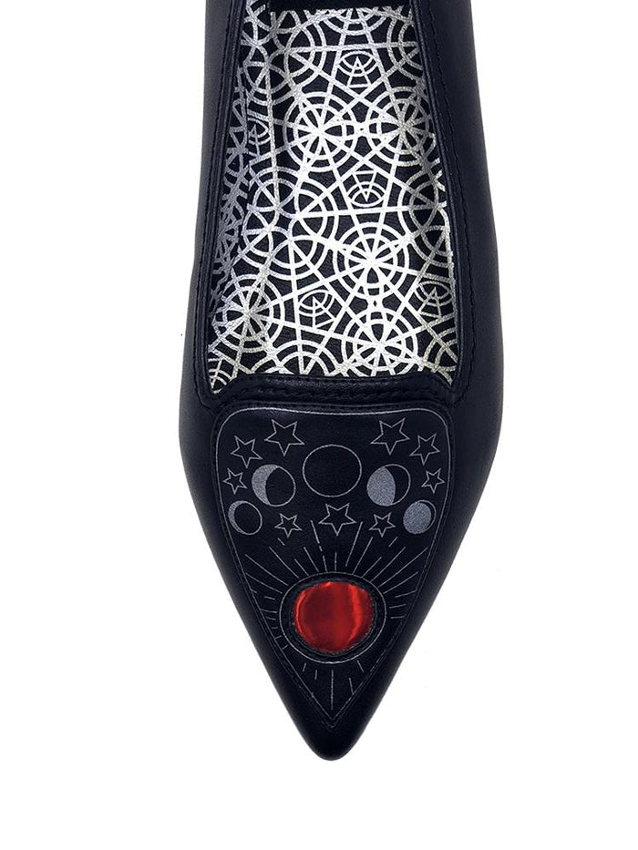 top of Black flats with pointy toe. Top of flats have silver Ouija board planchette print with red center. Inside sole of shoe is a black and white spiderweb-like pentagram print.