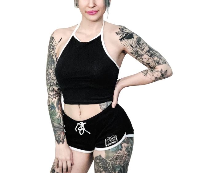 Black shorts with white trim and white planchette rose design on both buttcheeks, white drawstring and white spell book design on front left