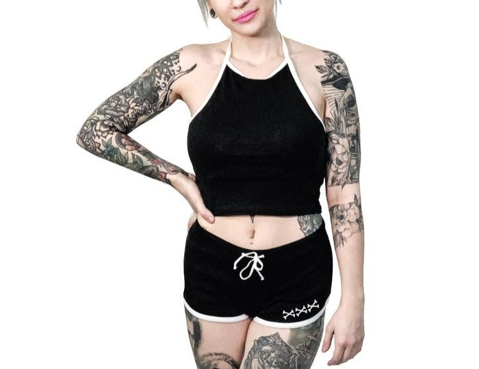Women's black shorts with whitetrim and white skeleton hand middle finger design on right buttcheek, white drawstring and white cross bones on front left