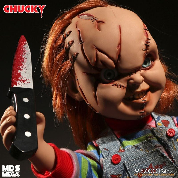 Chucky doll holding a knife with a dark background