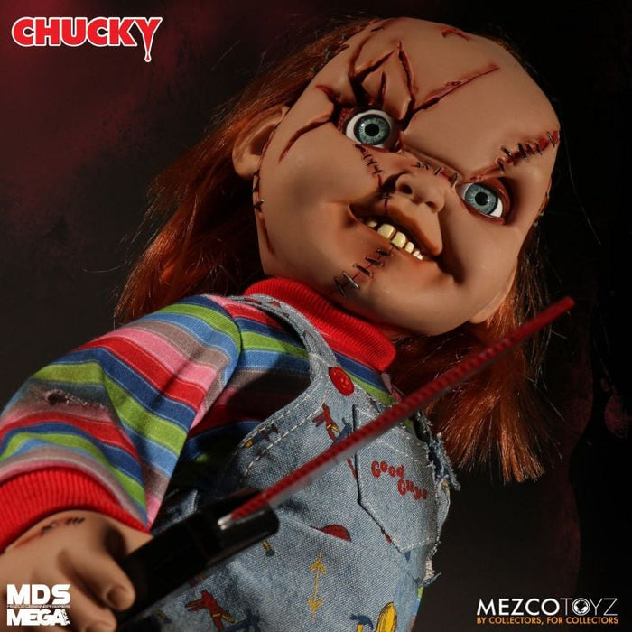 Chucky doll with red hair, striped shirt, and overalls holding an arrow, with 'MDS Mega' and 'MEZCO TOYZ' branding.