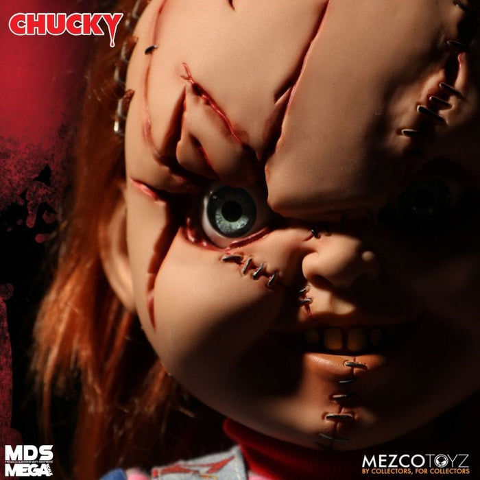 Close-up of a Chucky doll with red hair and visible eyes, branded by Mezco Toyz.