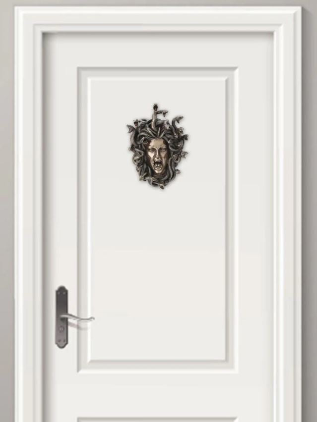 Bronze painted Medusa snake head with open mouth hanging on door