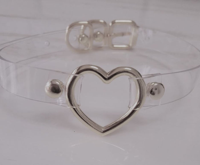 front view of Clear pvc choker with Metal heart at front center and Adjustable buckle closure on back