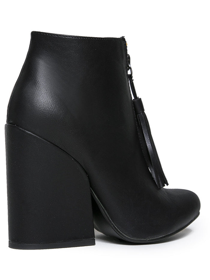 back side of Women's black vegan leather ankle boot with large wedge and front zip with black vegan leather tassel pull.