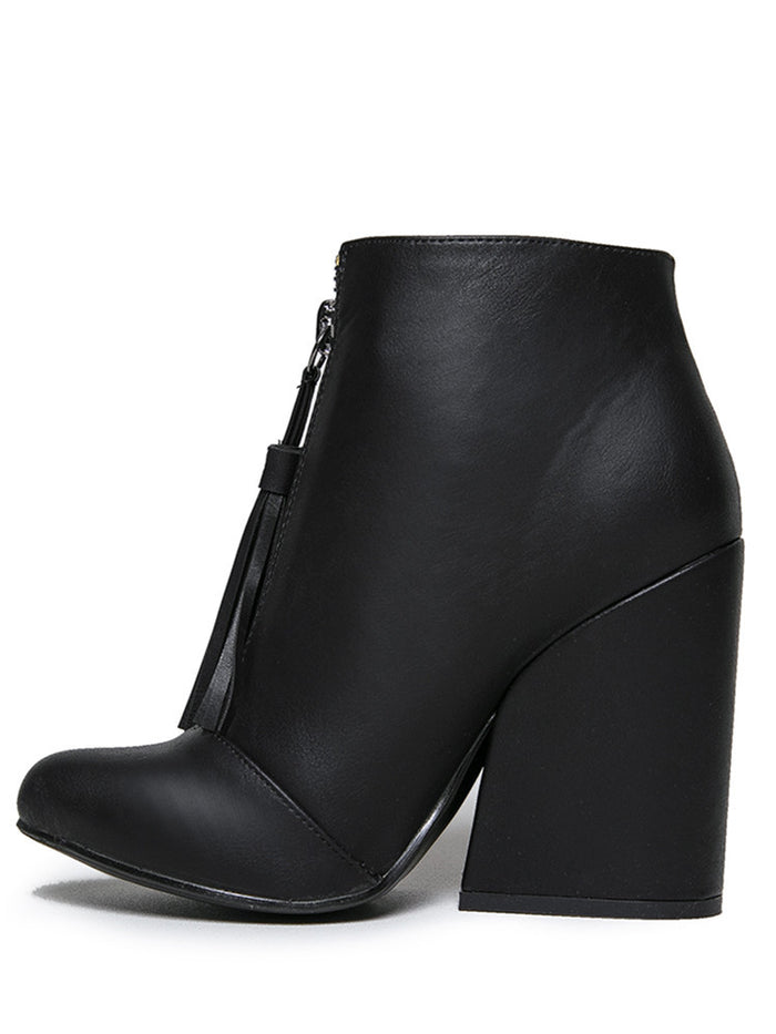 inner side of Women's black vegan leather ankle boot with large wedge and front zip with black vegan leather tassel pull.