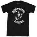 front of Black t-shirt with print of Elvira on front side. Print shows Elvira holding a skeleton and scythe. Top of shirt says "MISTRESS OF THE DARK" bottom says "HOLLYWOOD.