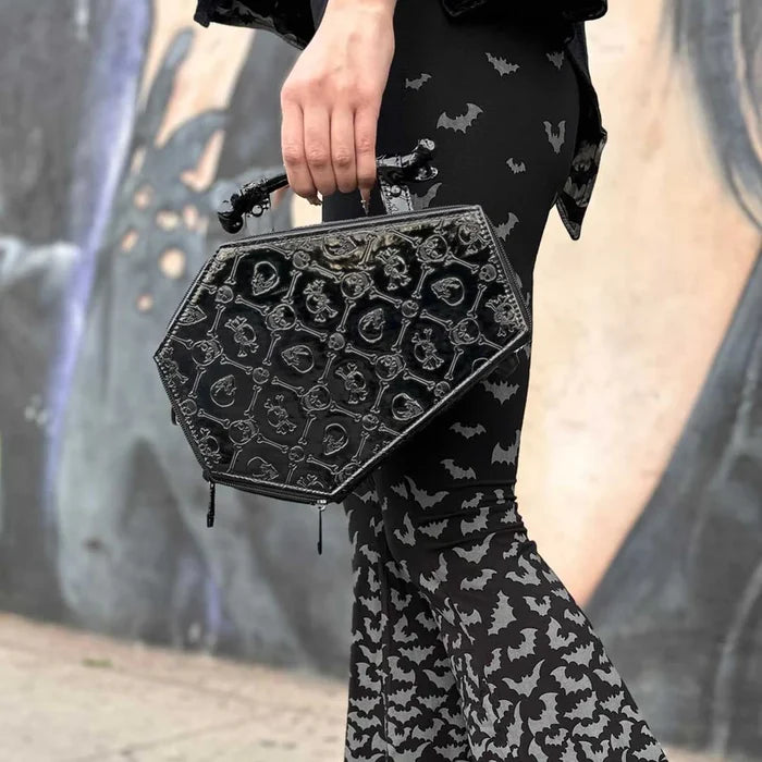 model holding bag wearing bat leggings