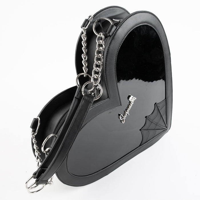 side view of heart shaped glossy black bag with a stitched spiderweb design at the bottom, chain link hardware and faux leather straps.