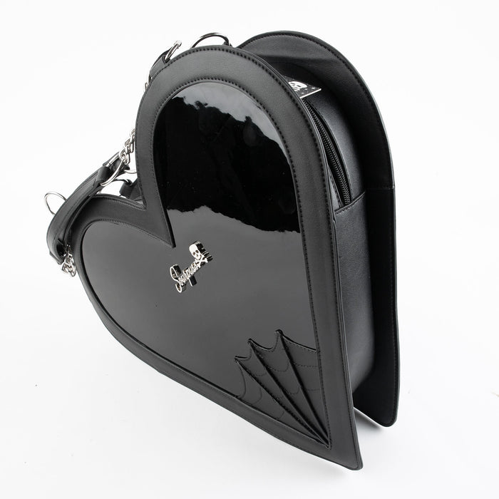 side view of heart shaped glossy black bag with a stitched spiderweb design at the bottom, chain link hardware and faux leather straps.