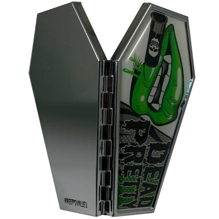 Black and green coffin shaped compact mirror with 2 regular mirrors inside. Design has a picture of a mouth with green lips, vampire teeth and text that reads "DEAD PRETTY."