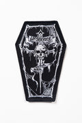 Black and white patch with a skull and coffin design on a white background