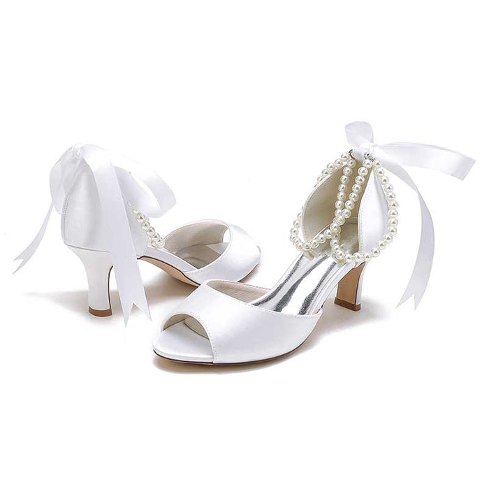 Elegant low heel satin bridal shoes with pearl accents and bow for a stylish wedding look