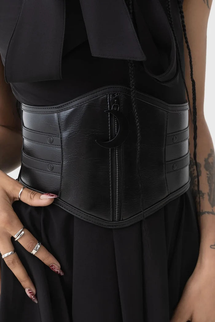Person wearing a black vegan leather waist belt with a plain background