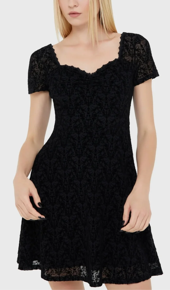 Model wearing a black lace dress on a white background