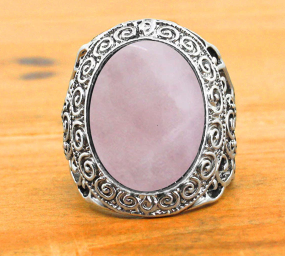 front of Silver colored ring with oval natural pink quartz stone.