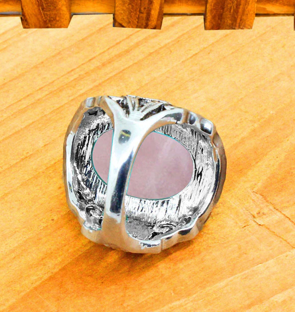 under side of Silver colored ring with oval natural pink quartz stone.