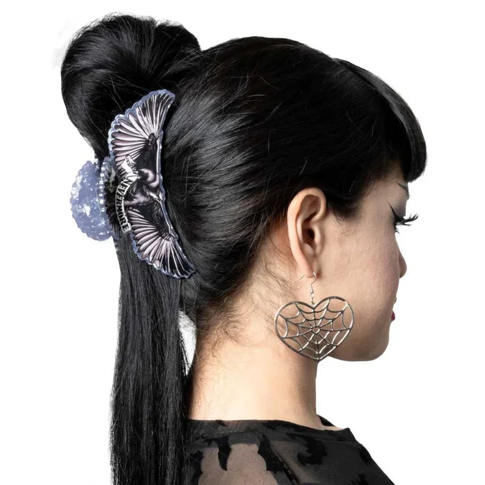 model wearing hair clip with heart shaped spider web earring on white background