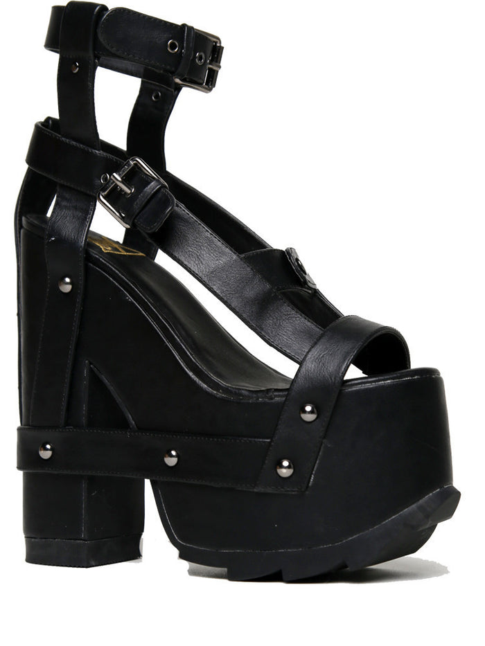 outer view of black vegan leather strappy platform sandal with 6.5" heel. Sandal has gunmetal hardware, adjustable ankle strap and adjustable side strap. Bottom of front platform has a fanned grip for better stability.