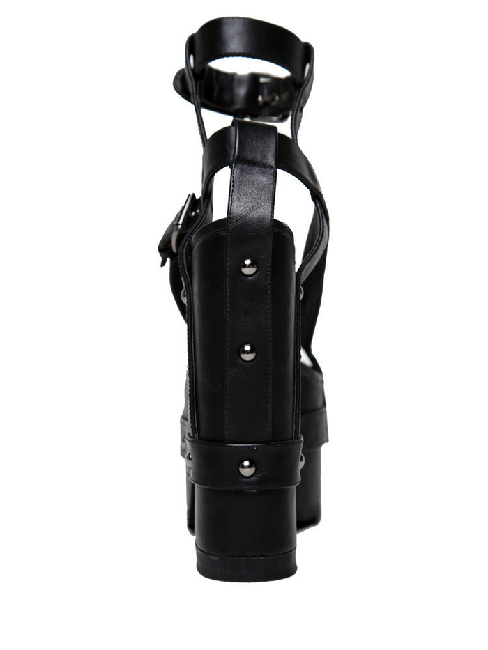back view of black vegan leather strappy platform sandal with 6.5" heel. Sandal has gunmetal hardware, adjustable ankle strap and adjustable side strap. Bottom of front platform has a fanned grip for better stability.