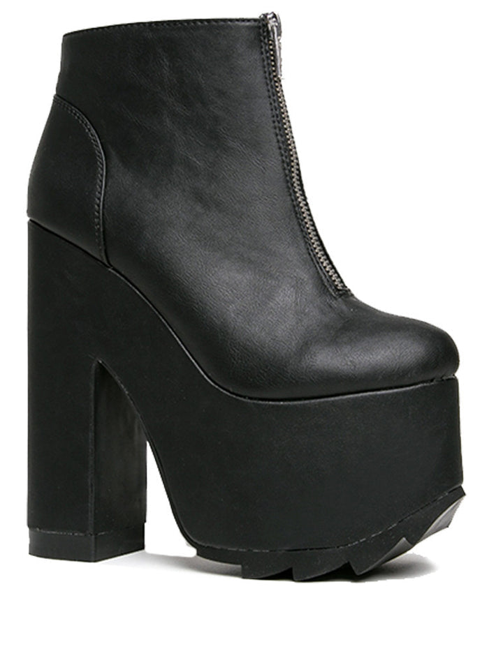 outer view of black vegan leather sleek 6.5" heel boot with silver front zip. Bottom of boot has a fanned front grip for better stability when walking.