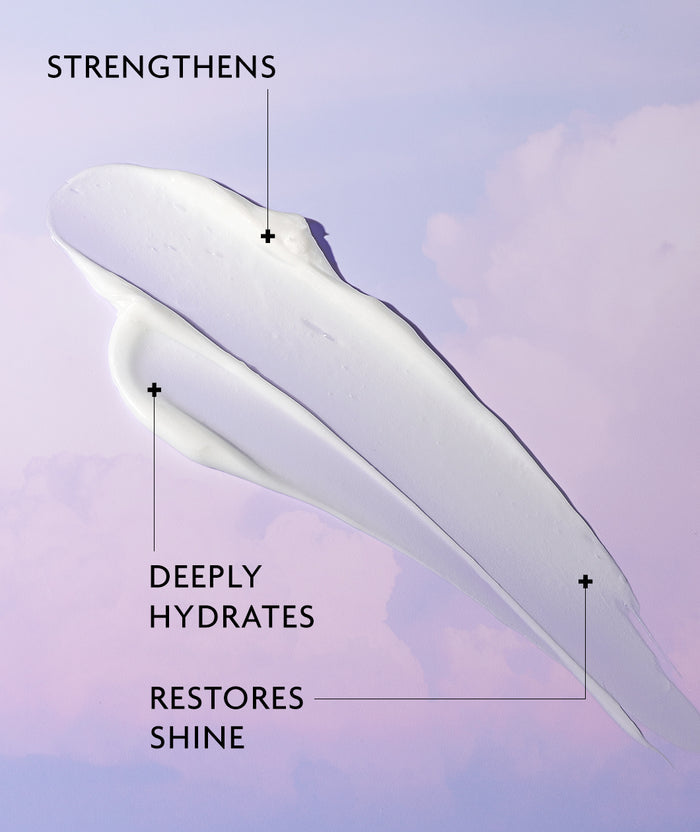 A thick white cream smear on a soft lavender and pale purple background, with text callouts reading 'STRENGTHENS,' 'DEEPLY HYDRATES,' and 'RESTORES SHINE.'.