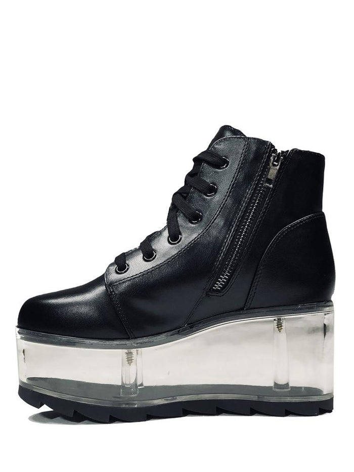 inner view of black vegan leather platform shoe with clear plastic platform. Shoe looks like a sneaker, but is super tall! Clear plastic bottom has a Velcro foot bed opening, to insert toys, candy or fun stuff into the clear bottom of the shoe.