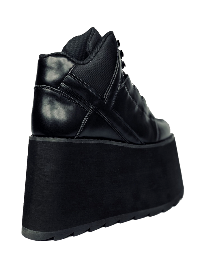 back view of black vegan leather platform shoe with EVA platform. Shoe looks like a sneaker, but super tall! Shoe has nylon details and mesh lining. Bottom of platform has a "fanned" grip to make the platform more stable.