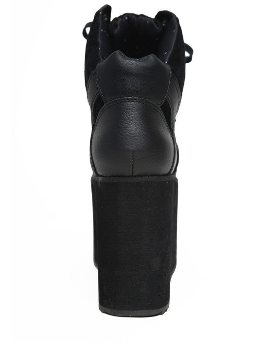 back view of black vegan leather platform shoe with EVA platform. Shoe looks like a sneaker, but super tall! Shoe has mesh lining.