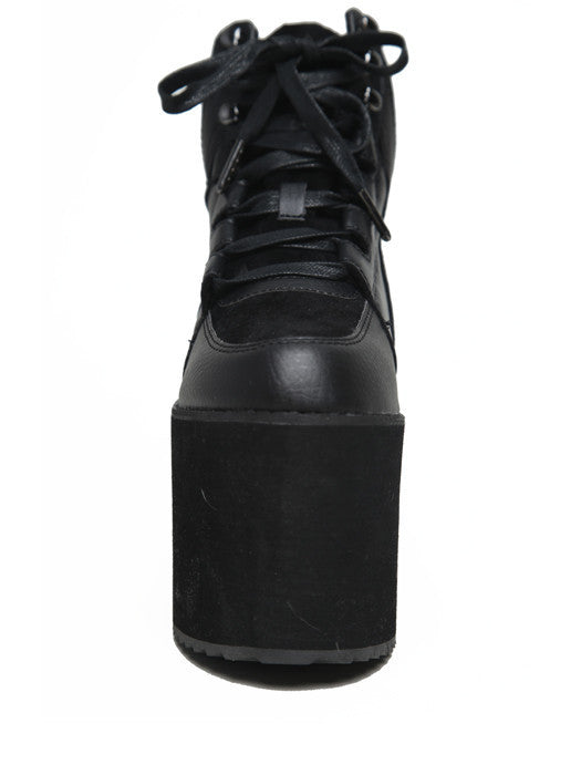 front view of black vegan leather platform shoe with EVA platform. Shoe looks like a sneaker, but super tall! Shoe has mesh lining.