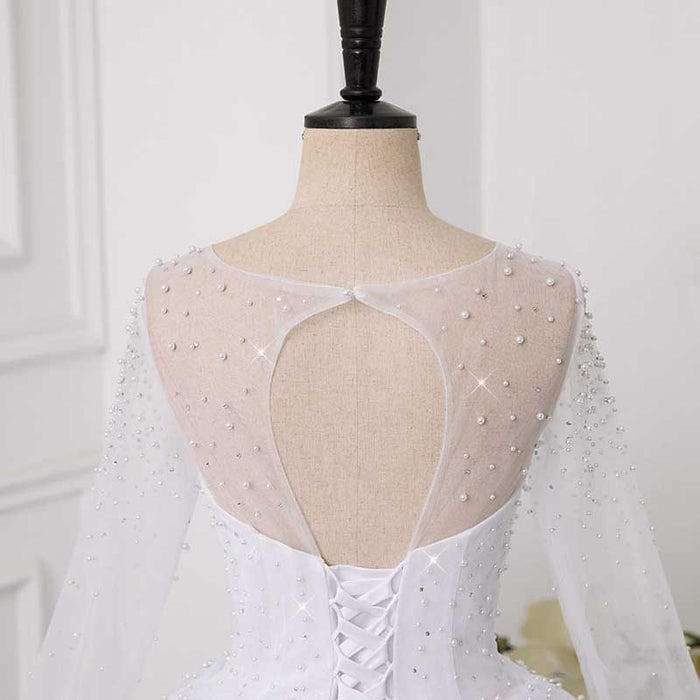 Elegant sweetheart tulle wedding dress featuring a beaded back and long sheer sleeves
