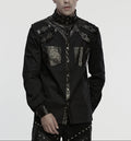 Person wearing a black, detailed shirt on a plain background