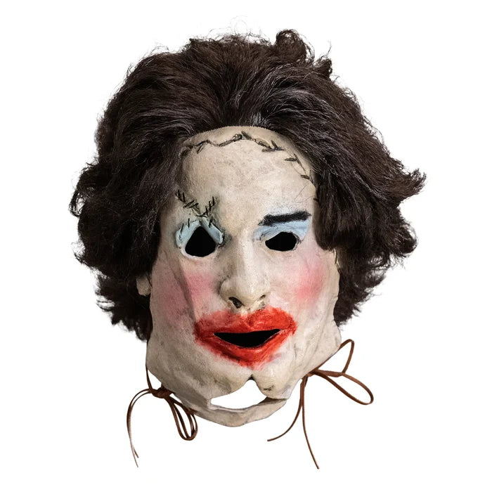 Mask with brown hair, white face, black eyes, red lips, and brown strings on a white background