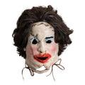 Mask with brown hair, white face, black eyes, red lips, and brown strings on a white background